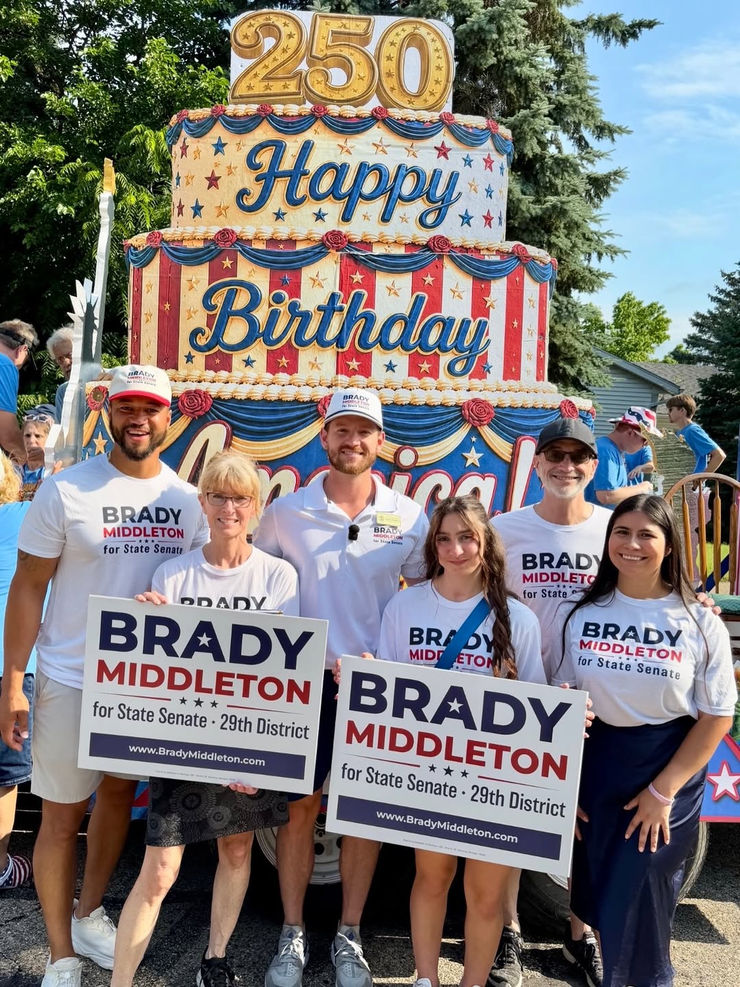 Team Middleton volunteers holding yard signs at a parade